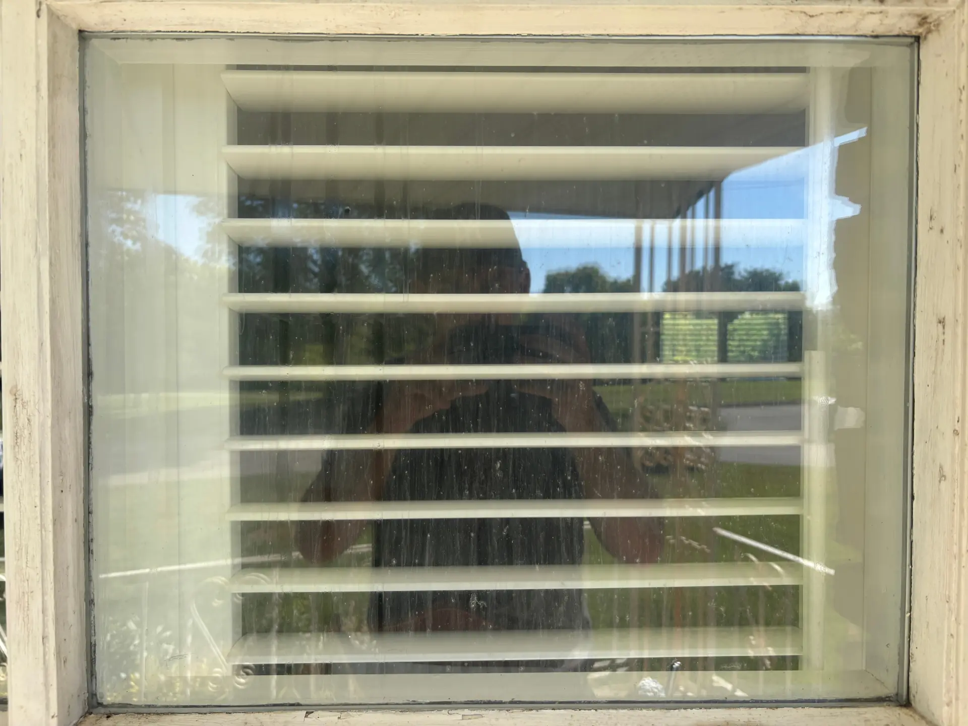 Exterior window cleaning in Preston, Ontario — a dusty French-pane window beside shutters restored to a bright, streak-free finish by Daylight Window Cleaning — before