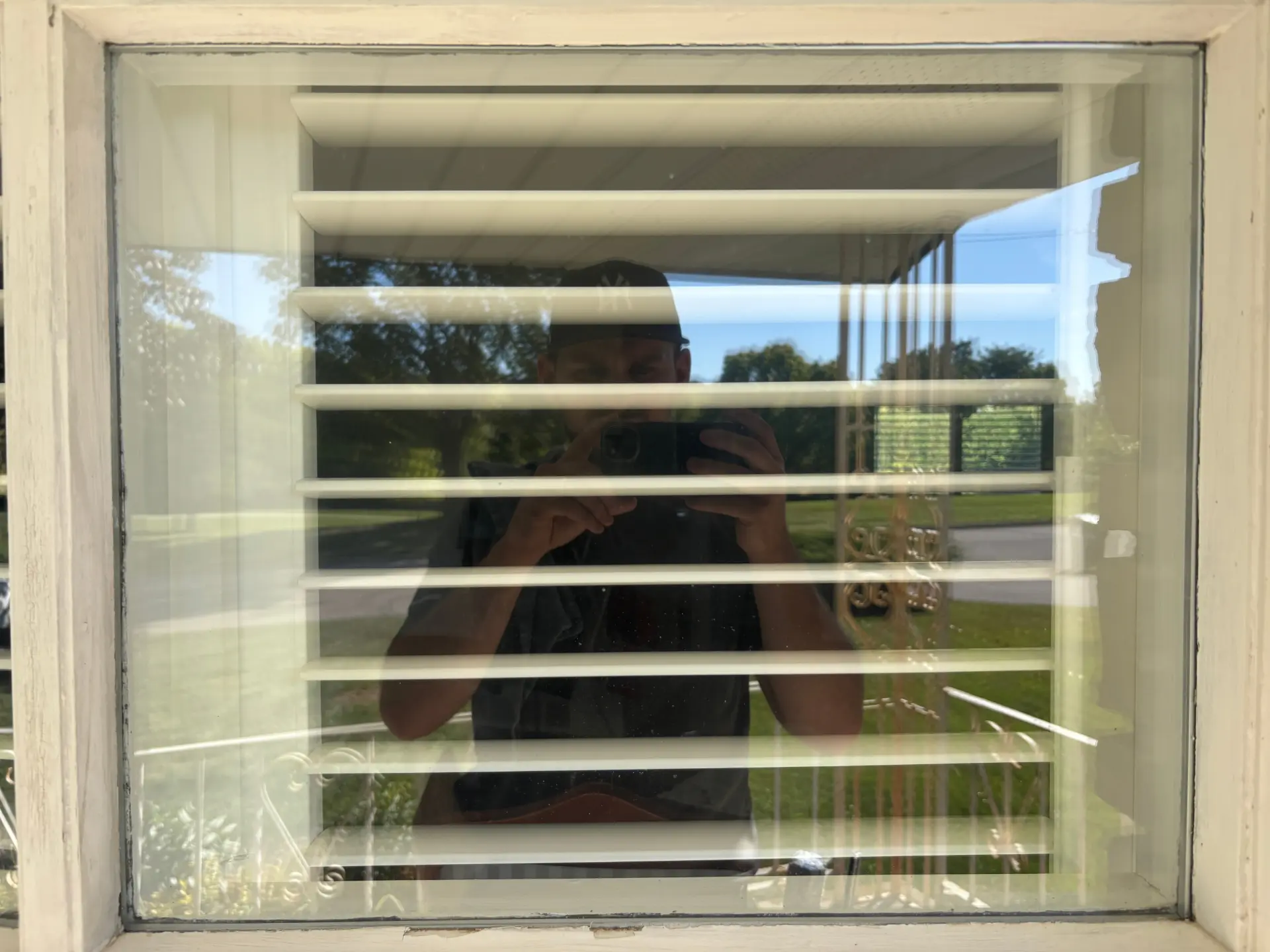 Exterior window cleaning in Preston, Ontario — a dusty French-pane window beside shutters restored to a bright, streak-free finish by Daylight Window Cleaning — after