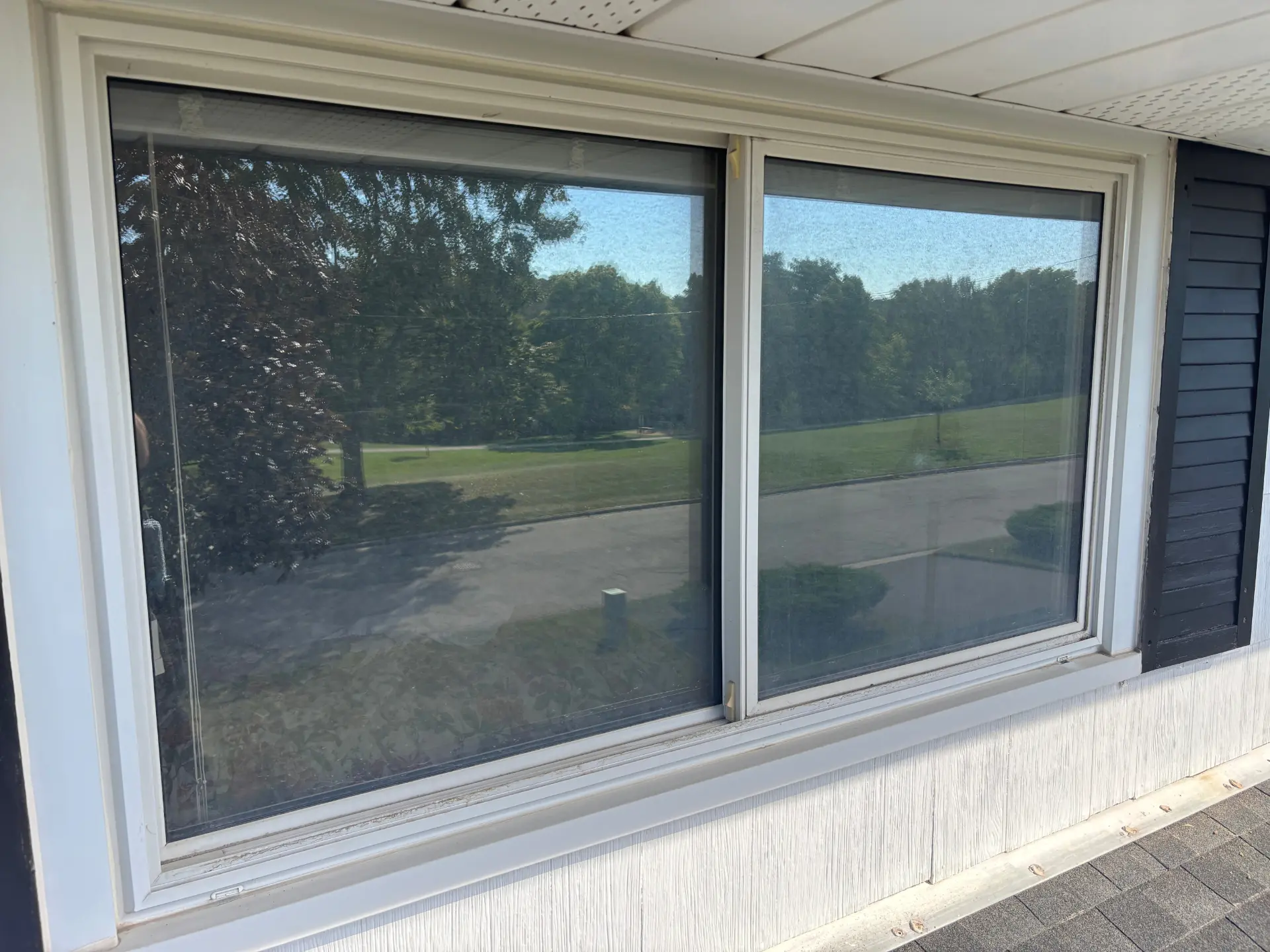 Exterior window cleaning in Cambridge, Ontario — a dirty, grimy house window transformed to a spotless, streak-free shine by Daylight Window Cleaning — before