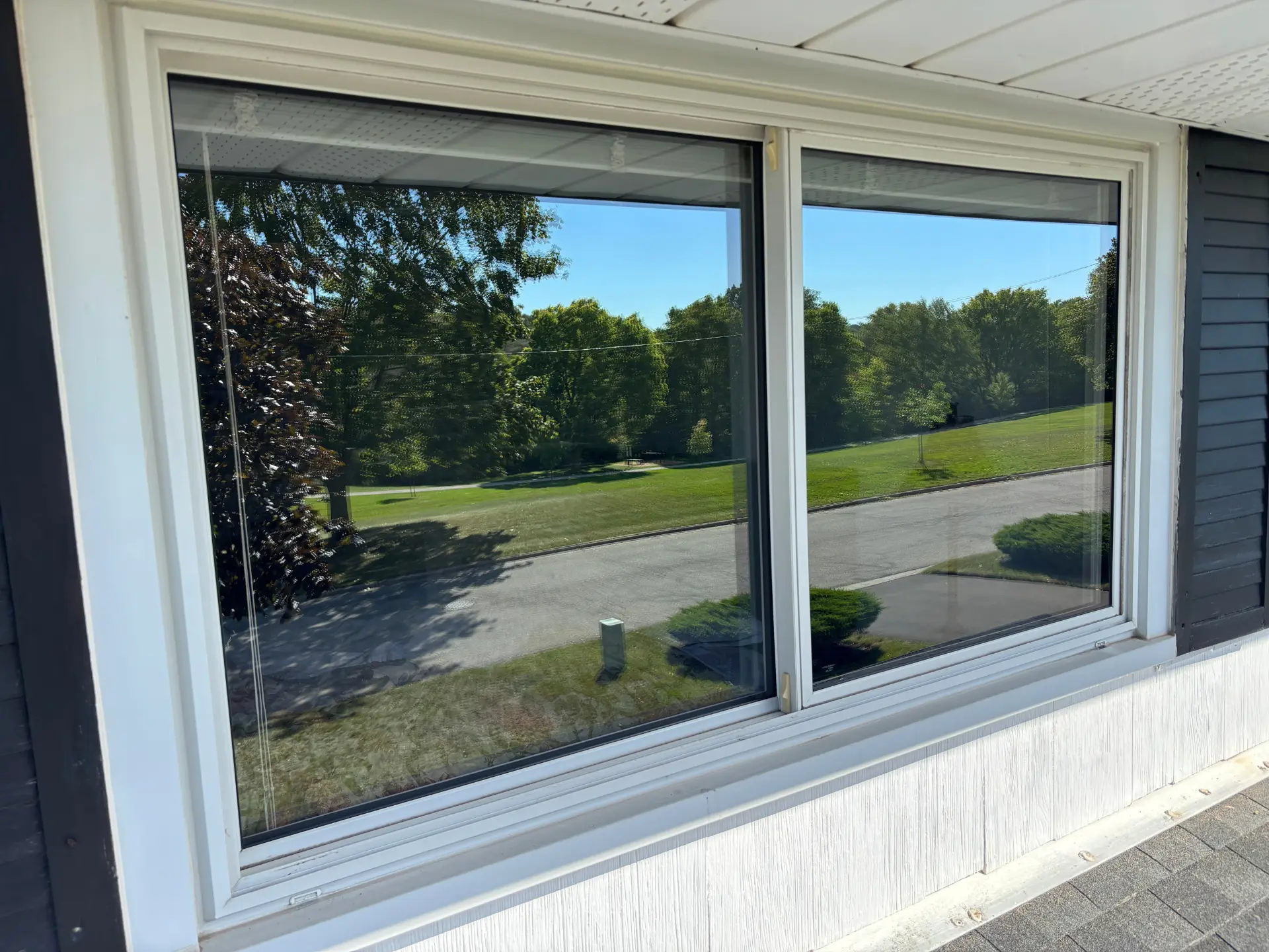 Exterior window cleaning in Cambridge, Ontario — a dirty, grimy house window transformed to a spotless, streak-free shine by Daylight Window Cleaning — after